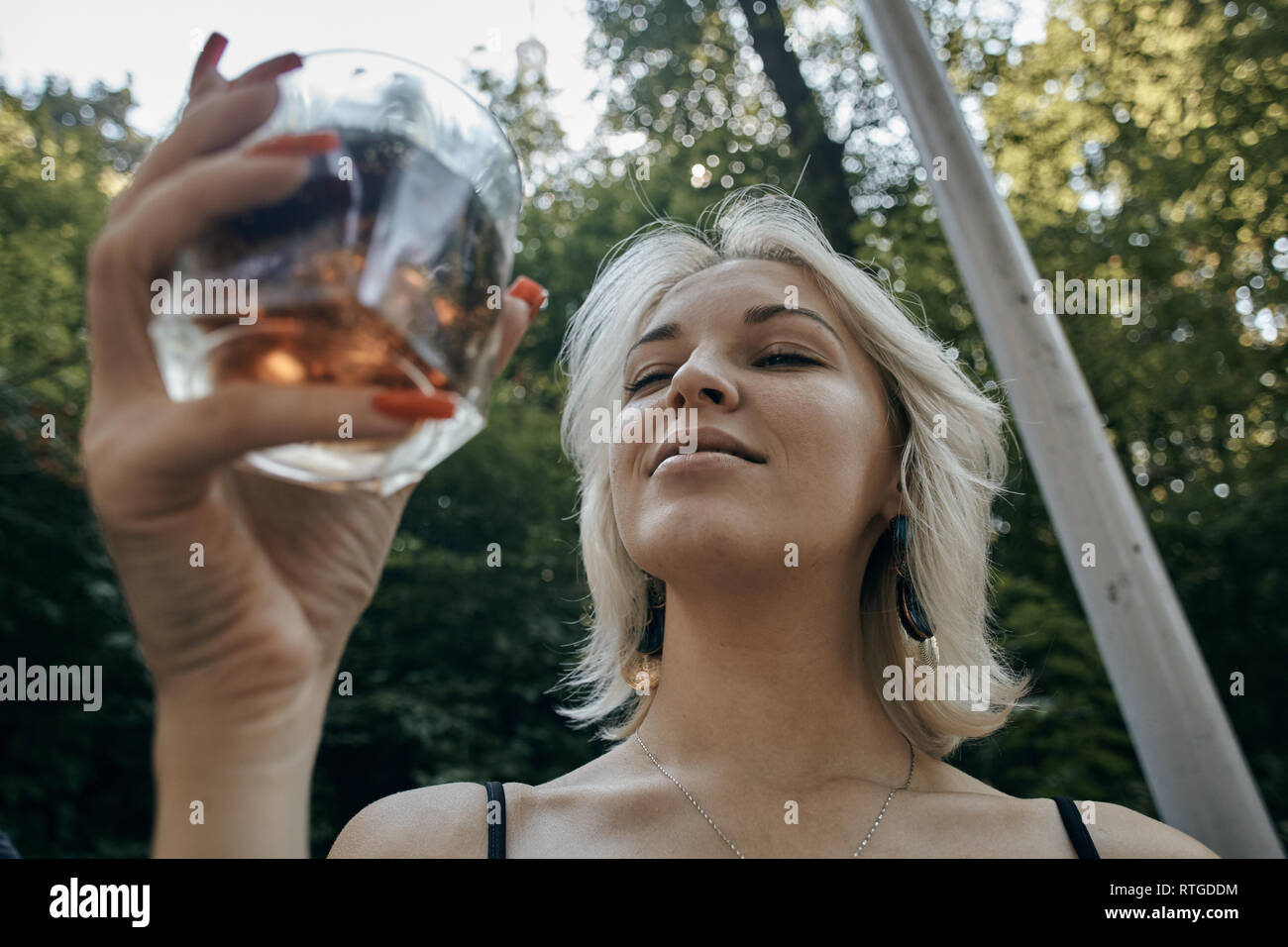 Young female with alcoholic drink looking very sad and depressed. Drunk young people (alcoholism, pain, pity, hopelessness, social problem of dependen Stock Photo