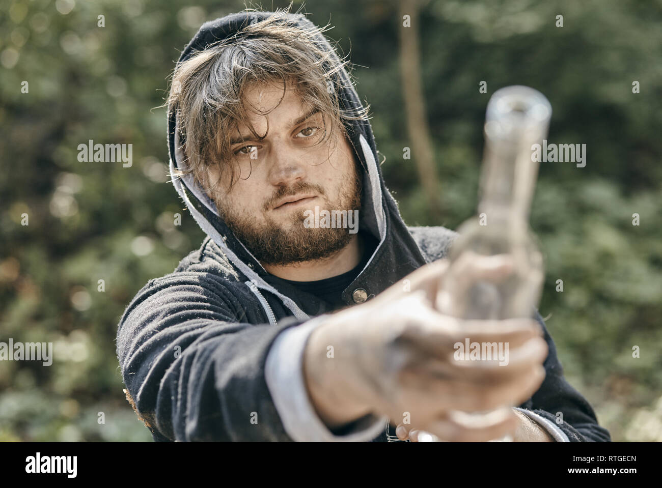 Close up of man holding a glass of vodka. Drunk young people. (alcoholism, pain, pity, hopelessness, social problem of dependence concept) Stock Photo