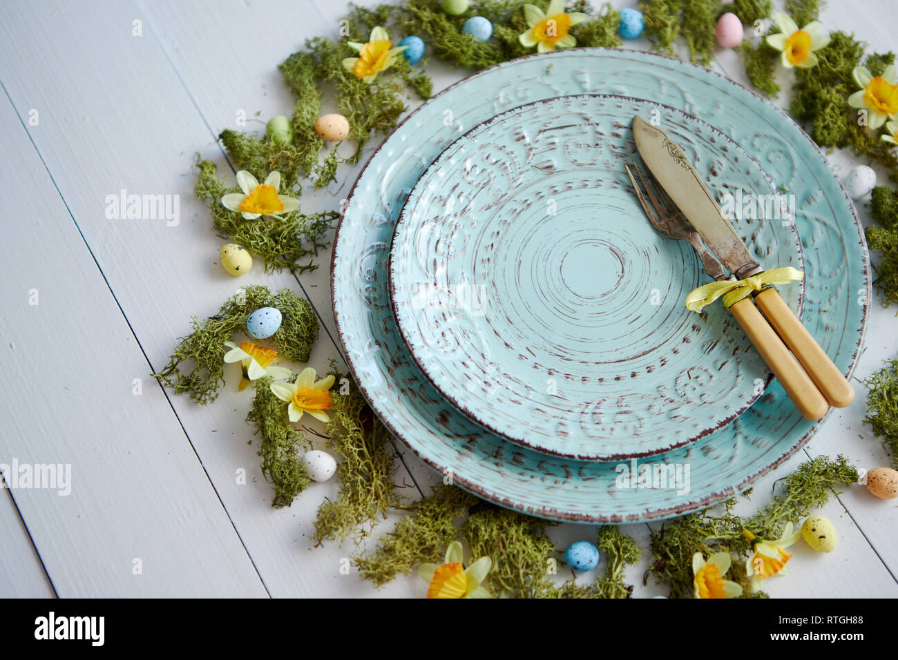 Easter table setting with flowers and eggs. Empty decorative ceramic plates Stock Photo
