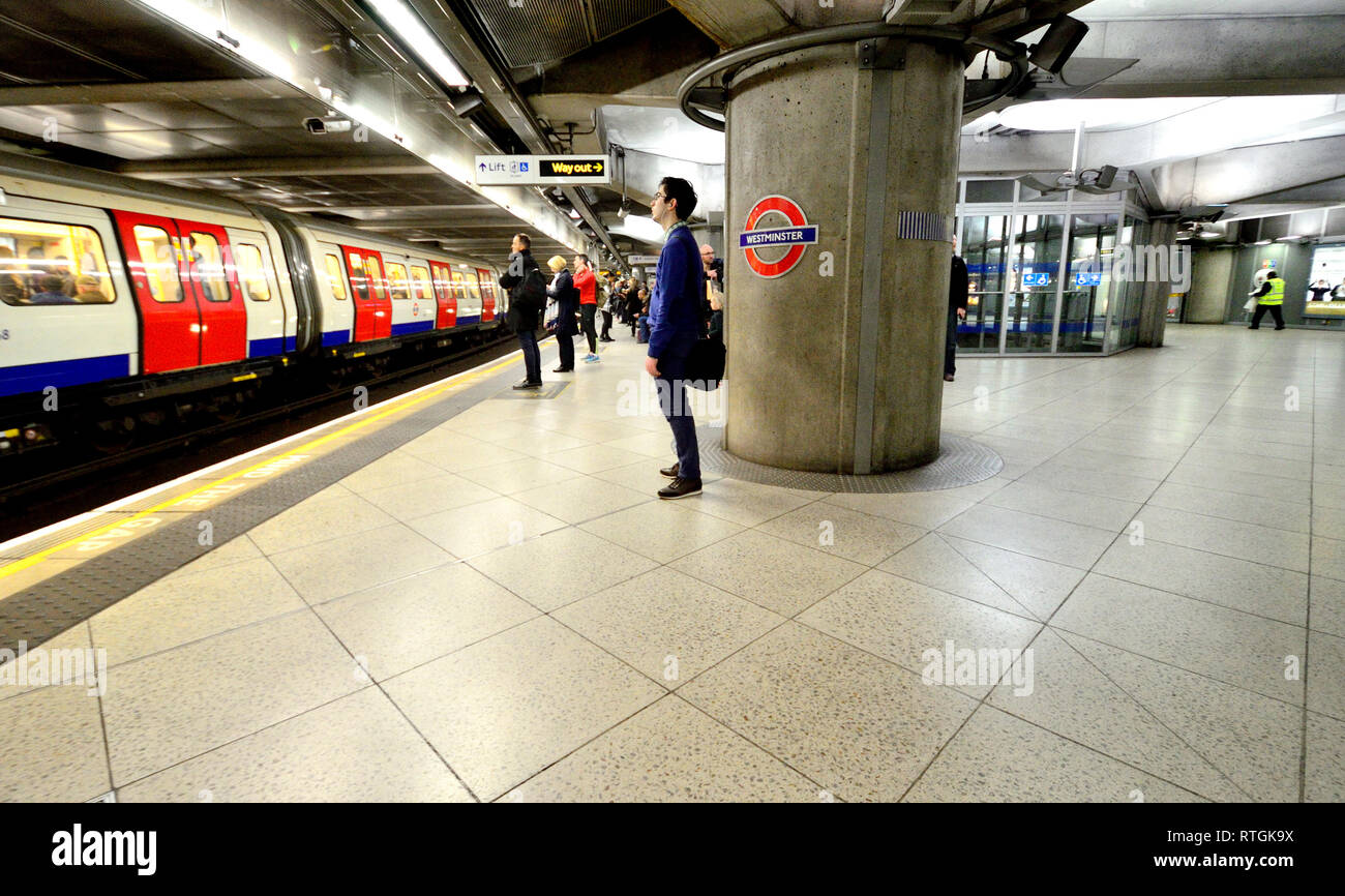 London, England, UK. Man waiting on the platform at Westminster Underground Station Stock Photo
