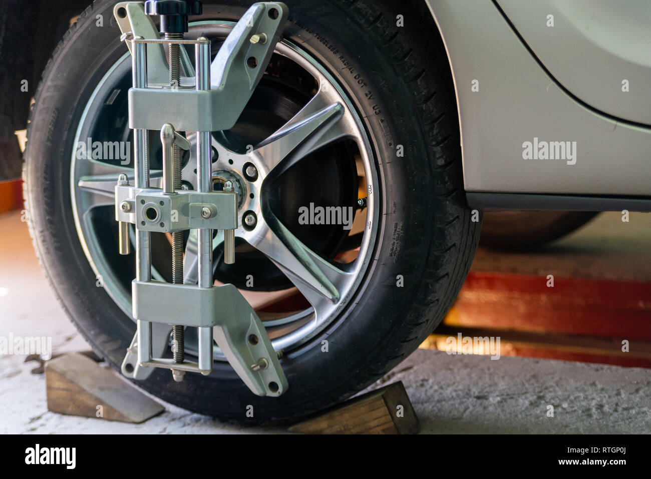 Car on stand with sensors on wheels for wheels alignment camber check in workshop of Service station. Stock Photo