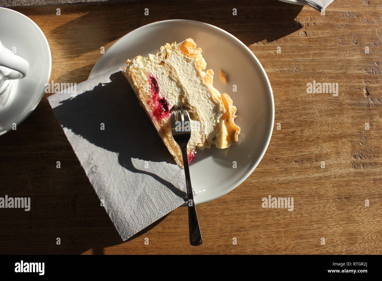 Single cream cake Flockensahne on plate with cake fork. Stock Photo