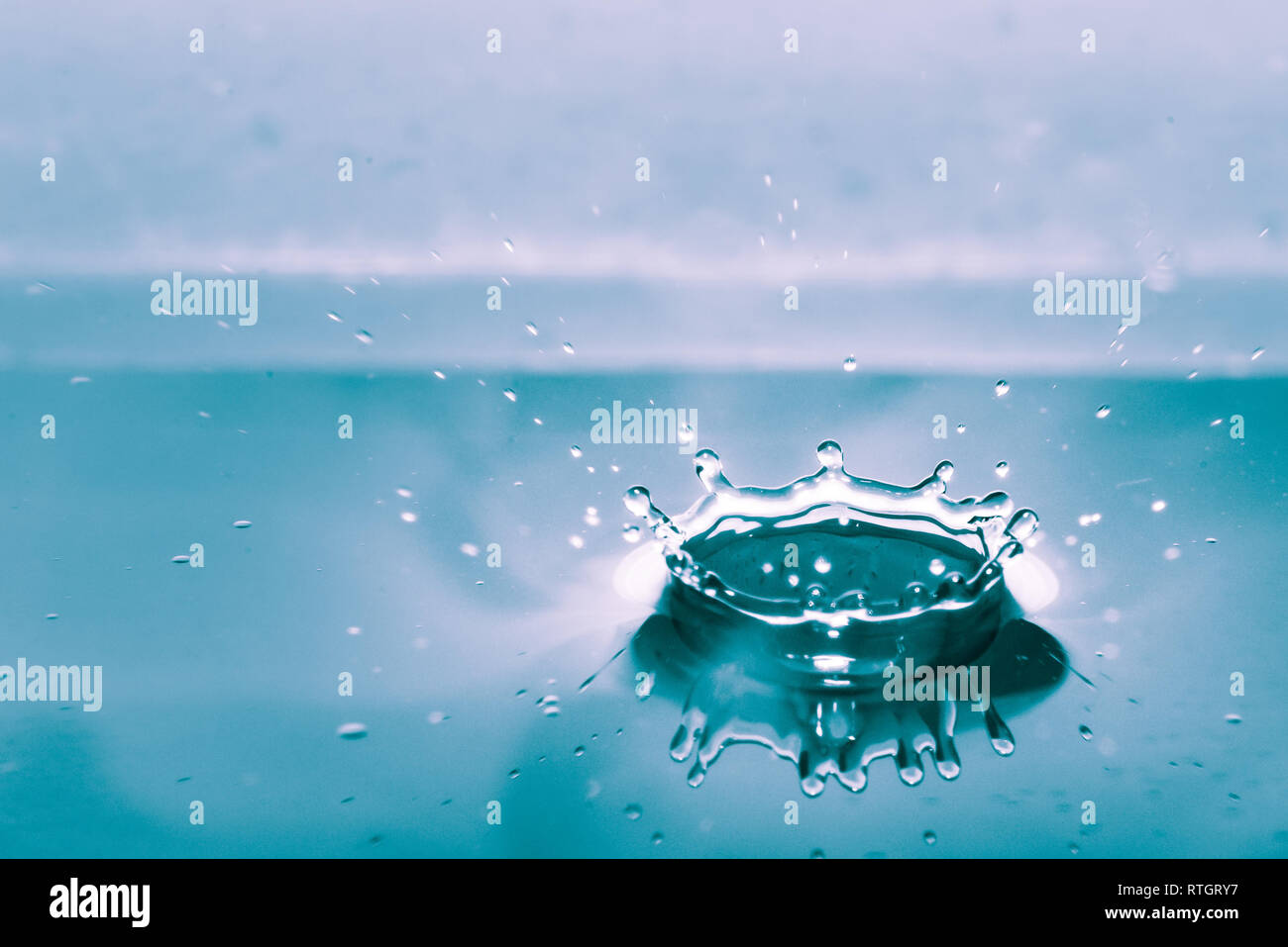 Water splash isolated on blue background Stock Photo