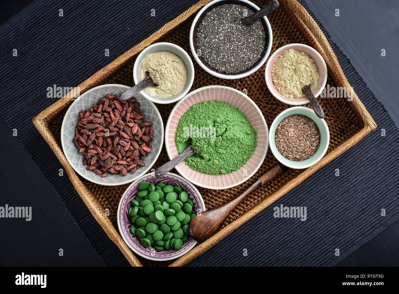 Different super foods in bowls on a rattan tray, top view Stock Photo