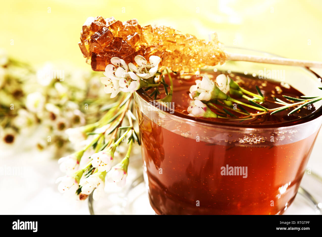 Beautifully decorated flower honey in a glass. On top there is a candy sugar stick. Stock Photo