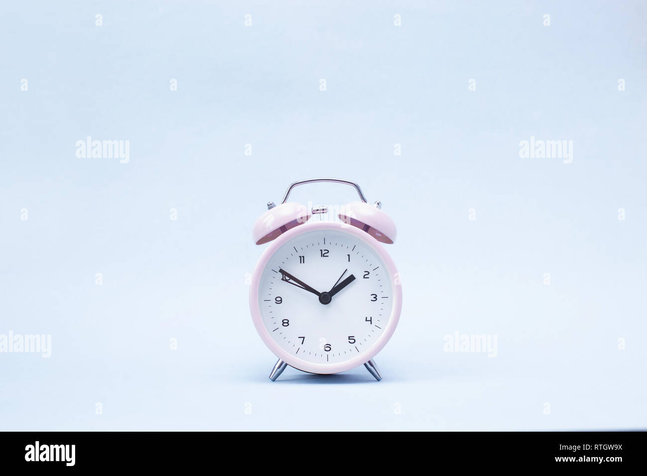 Pink ringing alarm clock on blue background Copy space Stock Photo - Alamy