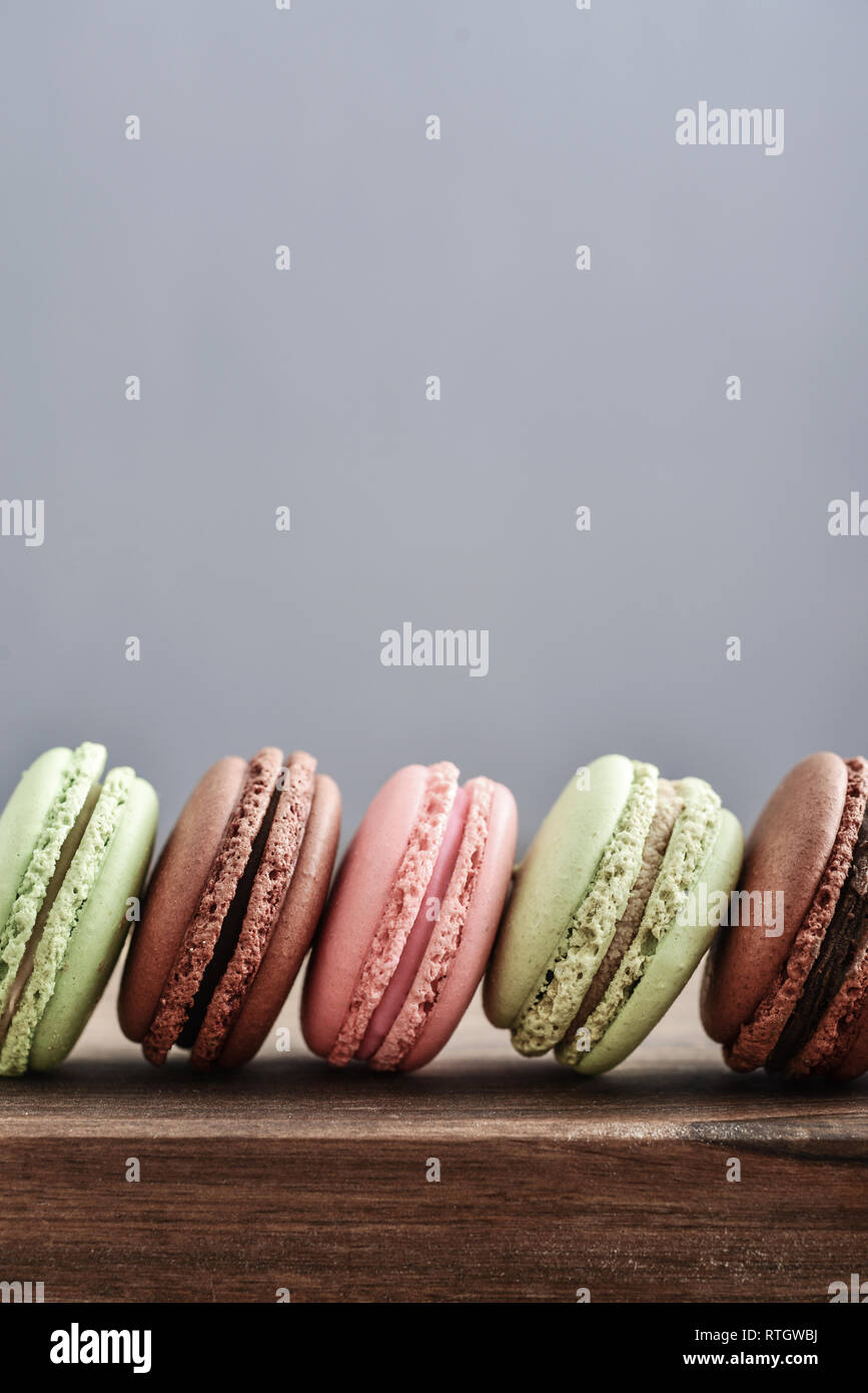 Different kinds of macaroons in row on blue background closeup Stock ...