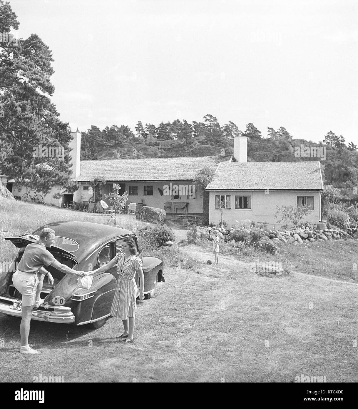 Lifestyle in the 1940s. A couple by their car in front of their house. Photo Kristoffersson ref AC120-1 Sweden 1947 Stock Photo