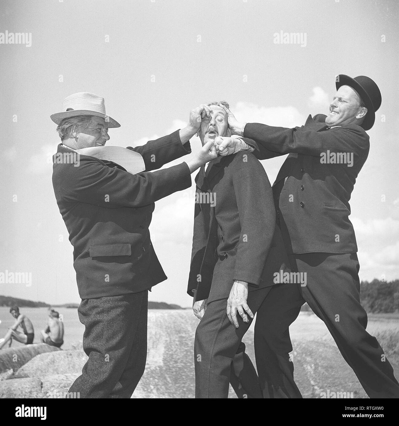 Men of the 1940s. An odd picture of three men involved in a physical argument, with a seemingly innocent man caught in the middle. Photo Kristoffersson Ref P49-4. Sweden 1945 Stock Photo