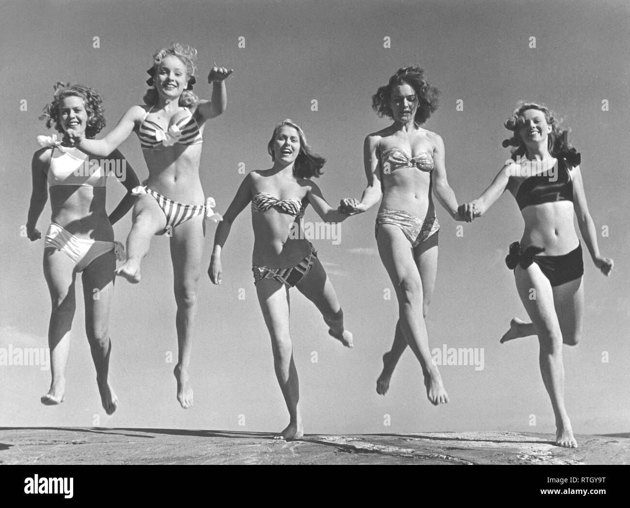 1940s summer. A group of young women in their bikinis are happy on this summer's day, jumping of joy. From left: Marianne Molander, Marianne Ljunggren, Eva Jönsson, Gunnel Wadner och Haide göransson. Photo Kristoffersson Ref AD26. Sweden 1947. Stock Photo