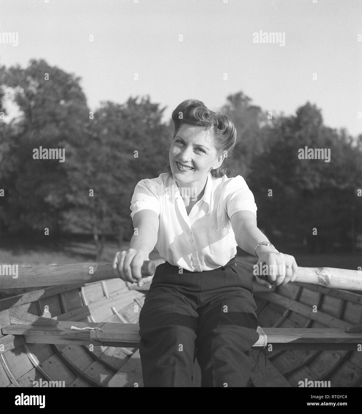 1940s summer. A young woman is rowing a boat. She is actress Barbro Kollberg.  Photo Kristoffersson ref E52-3. Sweden 1943 Stock Photo