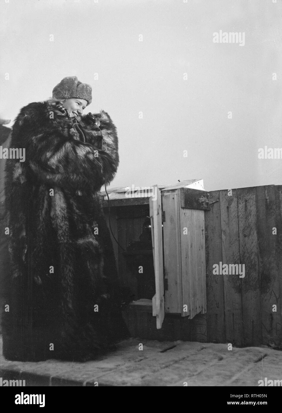The Winter War. A military conflict between the Soviet union and Finland. It began with a Soviet invasion on november 1939 when Soviet infantery crossed the border on the Karelian Isthmus. About 9500 Swedish volunteer soldiers participated in the war. Pictured a young woman on top of a building in Helsinki. She is part of the air defense personnel and has the important task to monitor and report any enemy aircrafts. A telephone is seen. The weather during the war was exteremely cold and was as low as minus 40 degrees. She is therefore wearing a warm fur coat.   January 1940. Photo Kristofferss Stock Photo