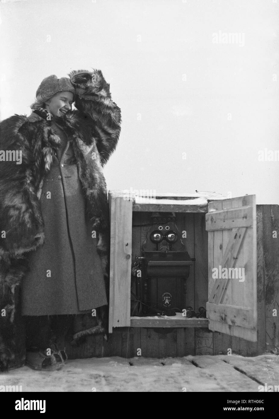 The Winter War. A military conflict between the Soviet union and Finland. It began with a Soviet invasion on november 1939 when Soviet infantery crossed the border on the Karelian Isthmus. About 9500 Swedish volunteer soldiers participated in the war. Pictured a young woman on top of a building in Helsinki. She is part of the air defense personnel and has the important task to monitor and report any enemy aircrafts. A telephone is seen. The weather during the war was exteremely cold and was as low as minus 40 degrees. She is therefore wearing a warm fur coat.   January 1940. Photo Kristofferss Stock Photo