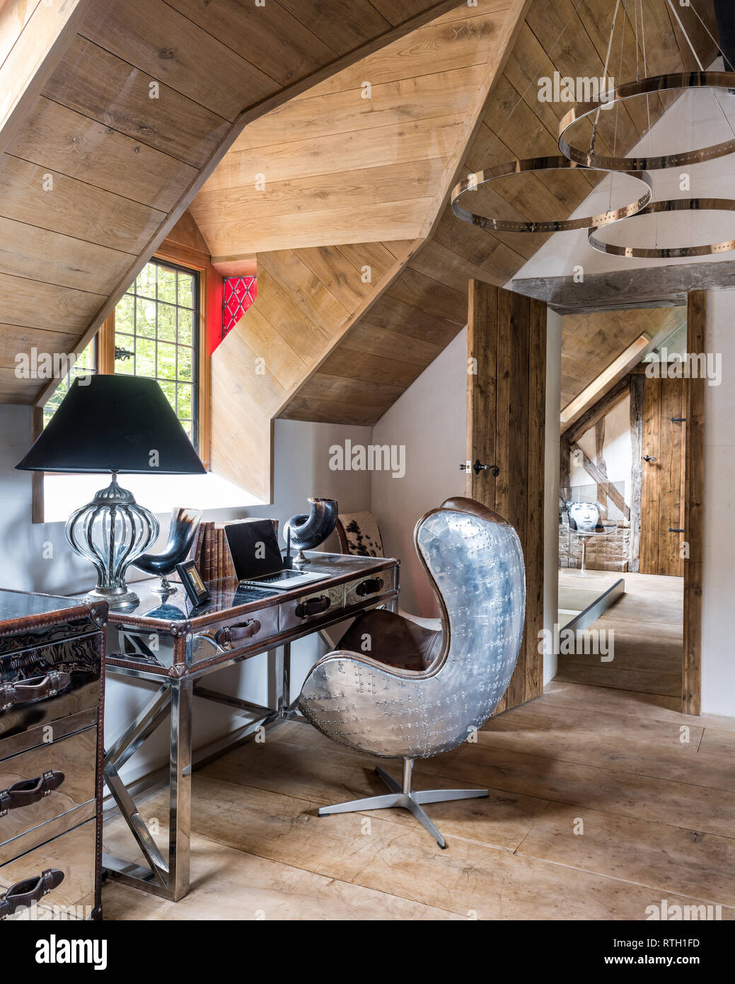 Chrome desk and Aviation armchair by Andrew Martin with doors made of reclaimed Scandinavian pine scaffold boards Stock Photo