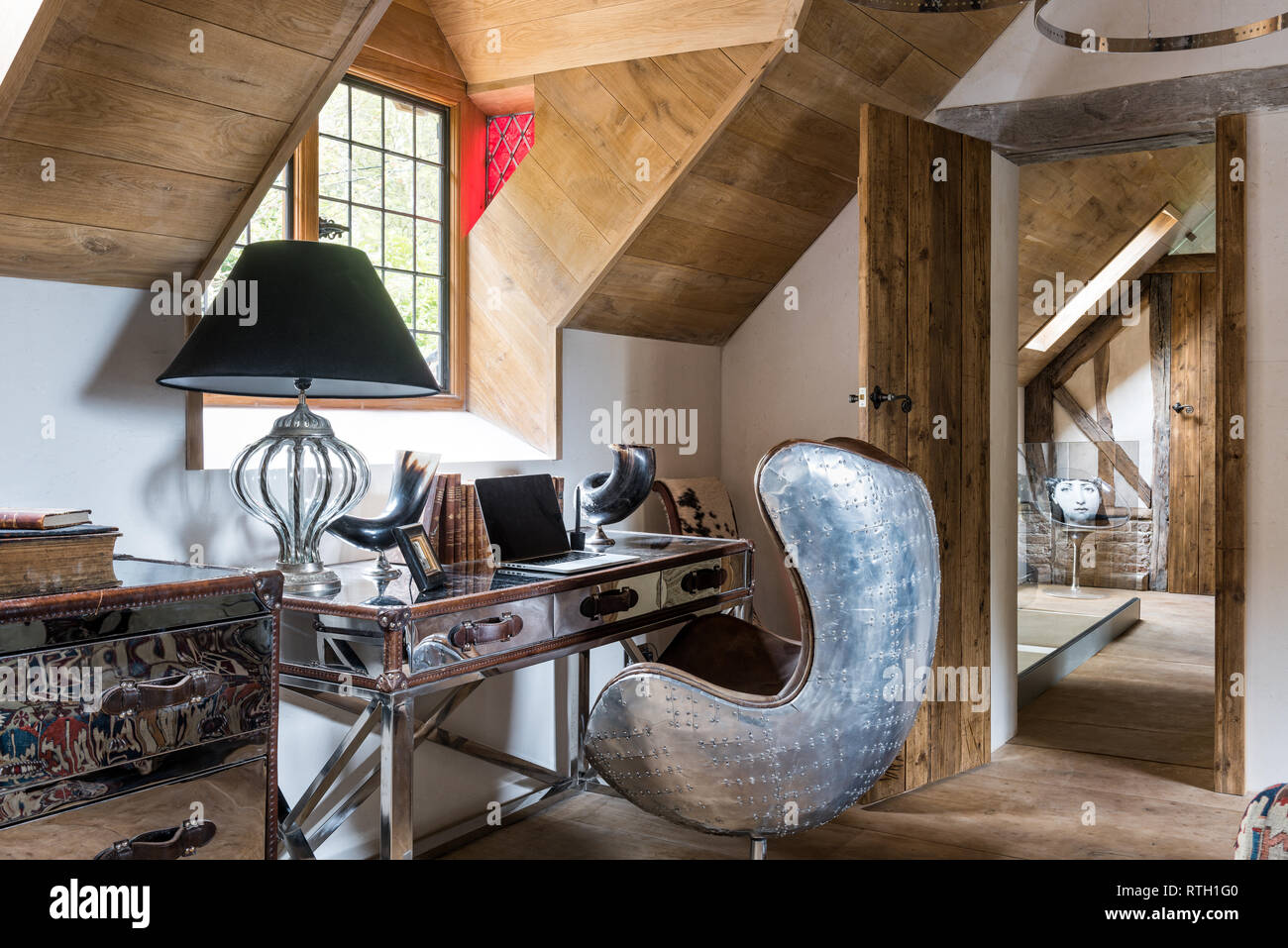 Chrome desk and Aviation armchair by Andrew Martin with doors made of reclaimed Scandinavian pine scaffold boards Stock Photo
