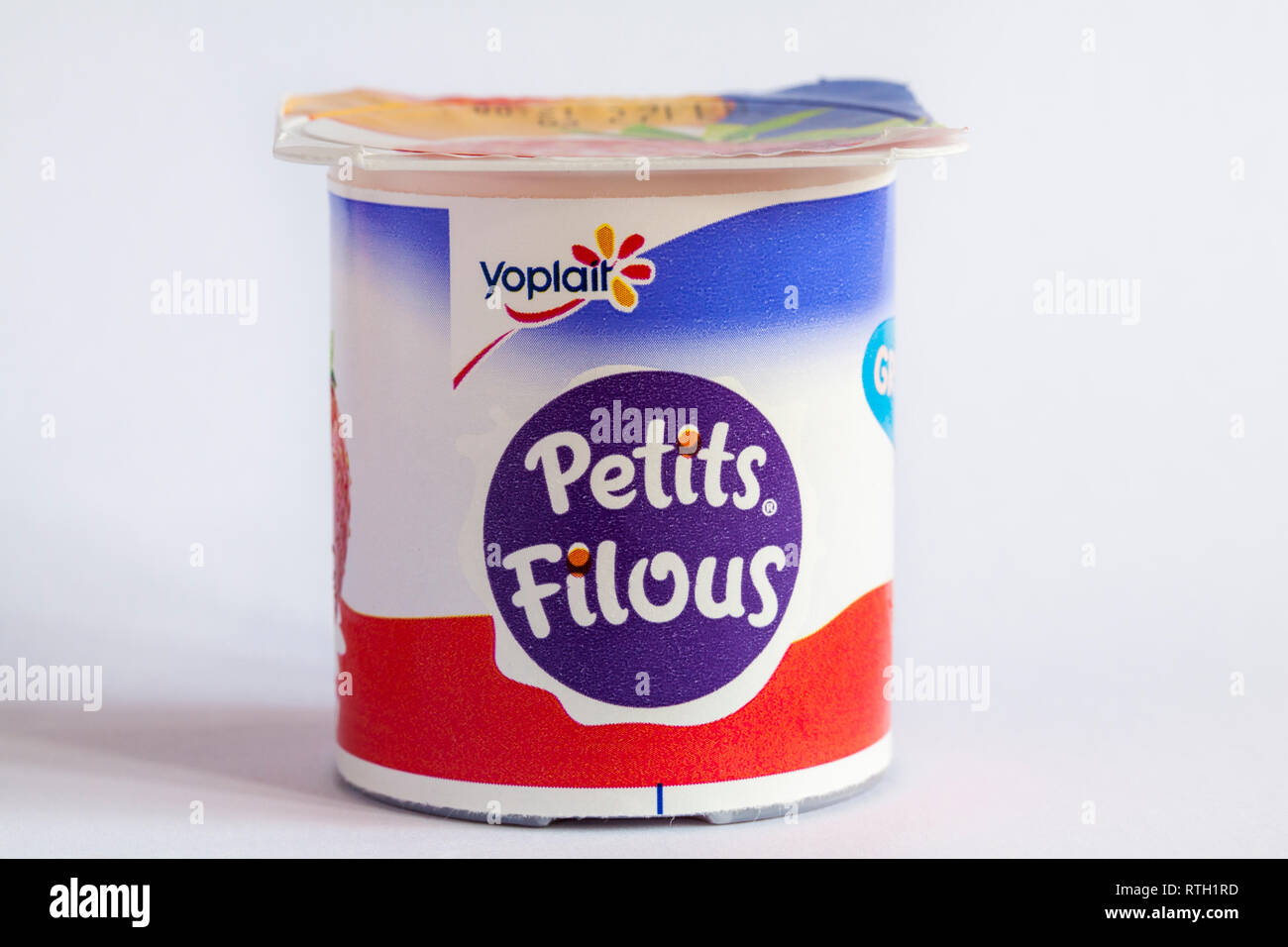 Pot of Yoplait Petits Filous yogurt isolated on white background - Greek style fruit layers - yoghurt Stock Photo