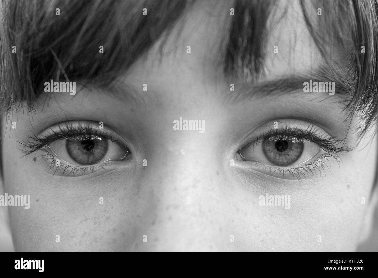 Black and white macro shot of the big intense eyes of a young child Stock Photo