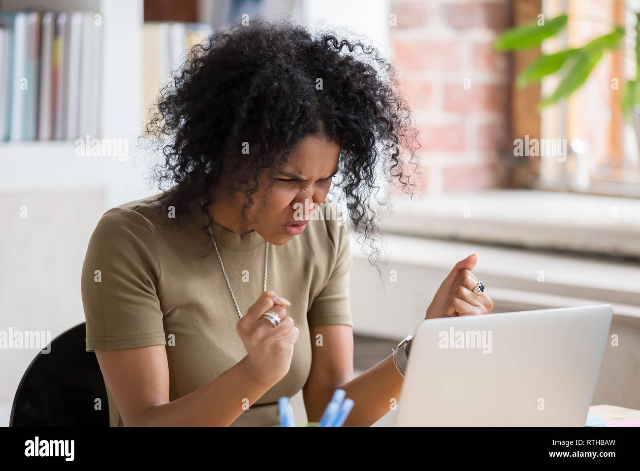 Angry mad african businesswoman feeling crazy furious hates stuck laptop Stock Photo