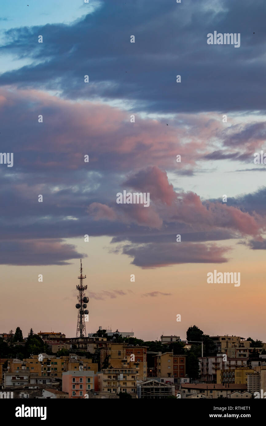 Communication tower against cloudy sunset sky over Matera, the Sassi di Matera, Basilicata, Southern Italy, warm colors scenery summer evening Stock Photo