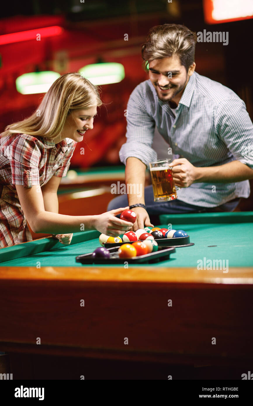 young smiling couple sorting balls for beginning billiard game Stock