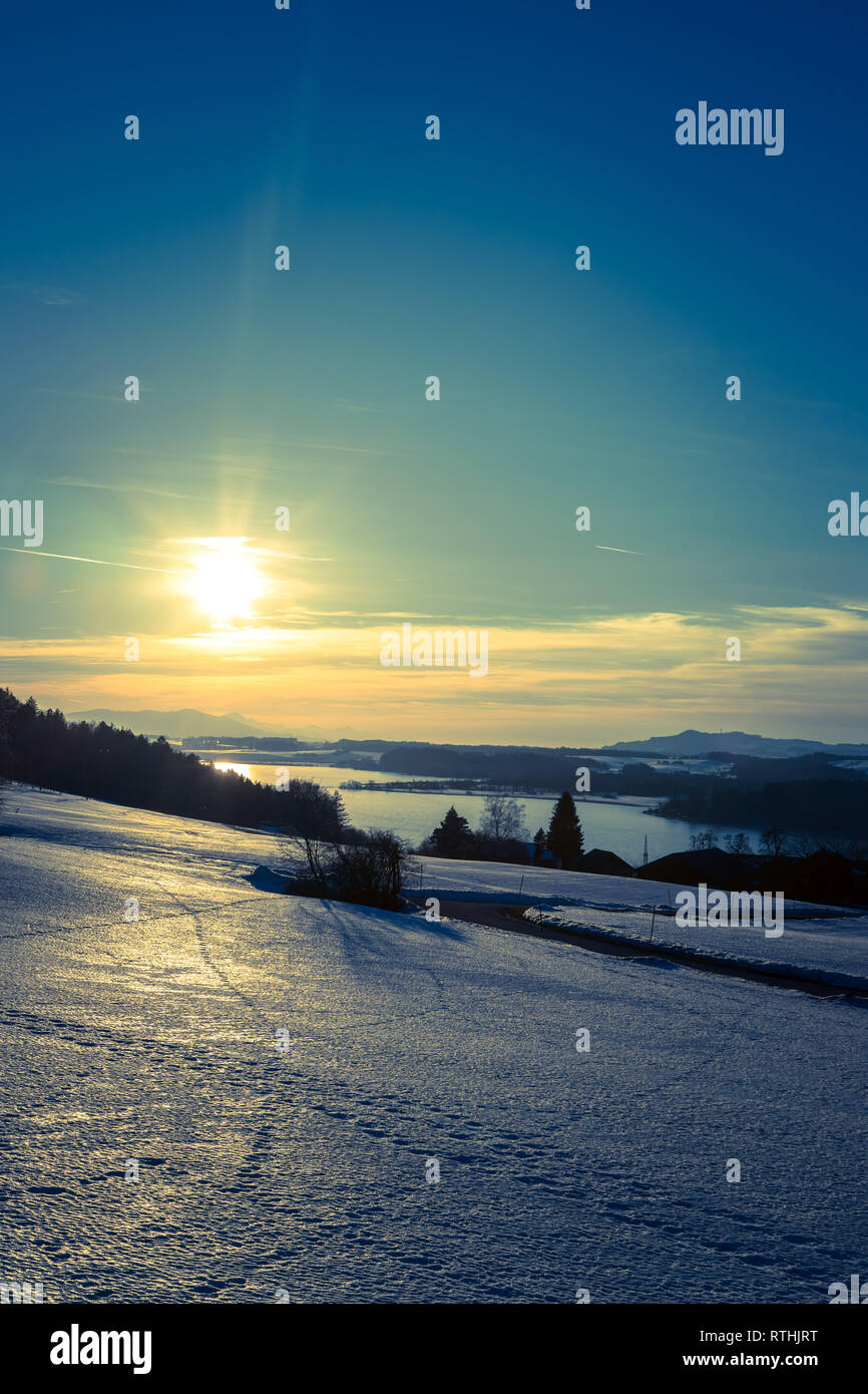 Lake, snowy fields and sundown scenery at Wallersee, Austria Stock