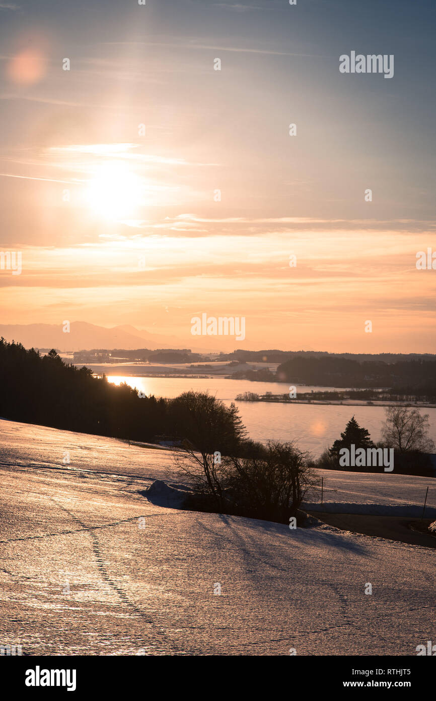 Lake, snowy fields and sundown: scenery at Wallersee, Austria Stock Photo