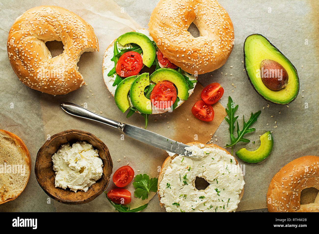 Vegetarian Bagel sandwich with cheese cream, avocado and tomato. Healthy vegetarian and vegan food. Stock Photo