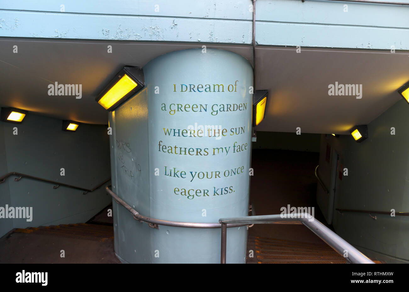 Entrance stairs and stairway to an underpass near London Waterloo Station, Lambeth, London SE1 with words of poetry by Sue Hubbard written on a pillar Stock Photo
