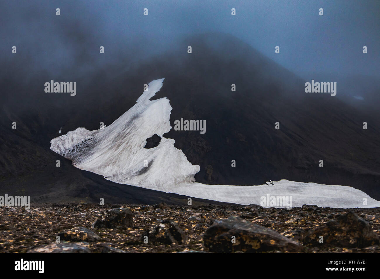 Snow patch looks like alien head on mountain in Highlands of Iceland at summer season Stock Photo