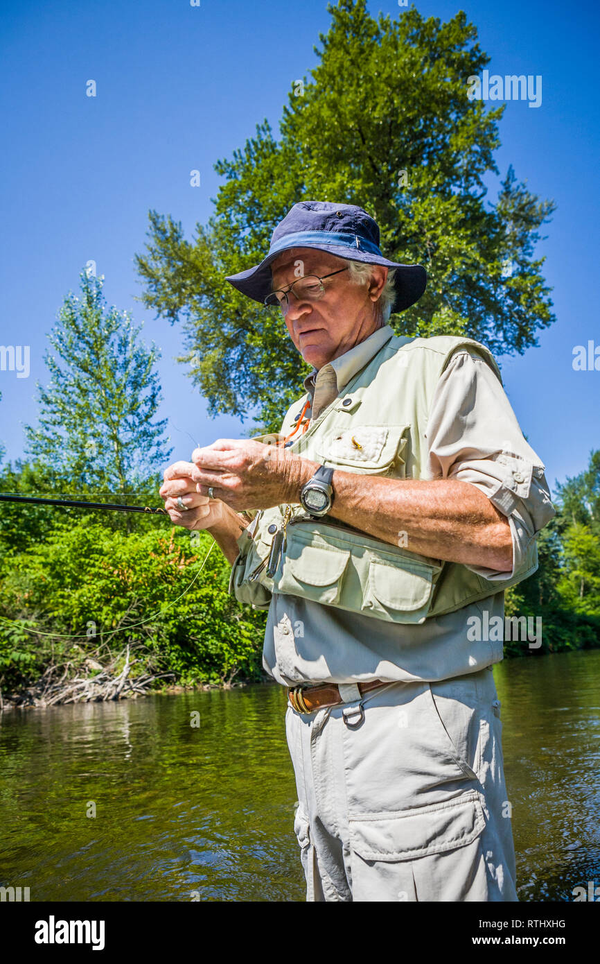 A 70 year old man fly fishing in the Cedar River, Western Washington