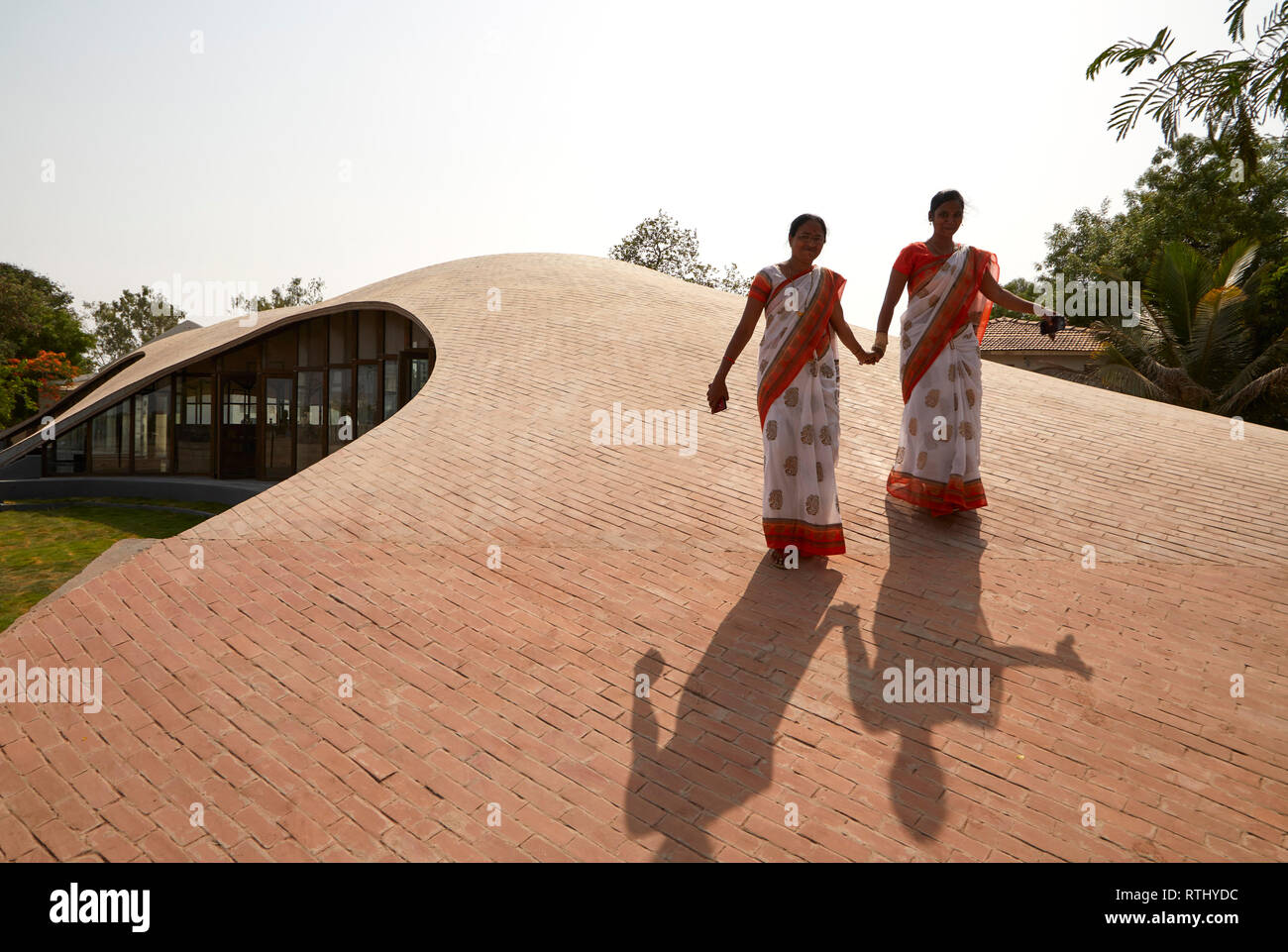Teachers walk hand in hand on roof. Maya Somaiya Library, Kopargaon/Maharashtra, India. Architect: Sameep Padora and associates (SP+A), 2018. Stock Photo