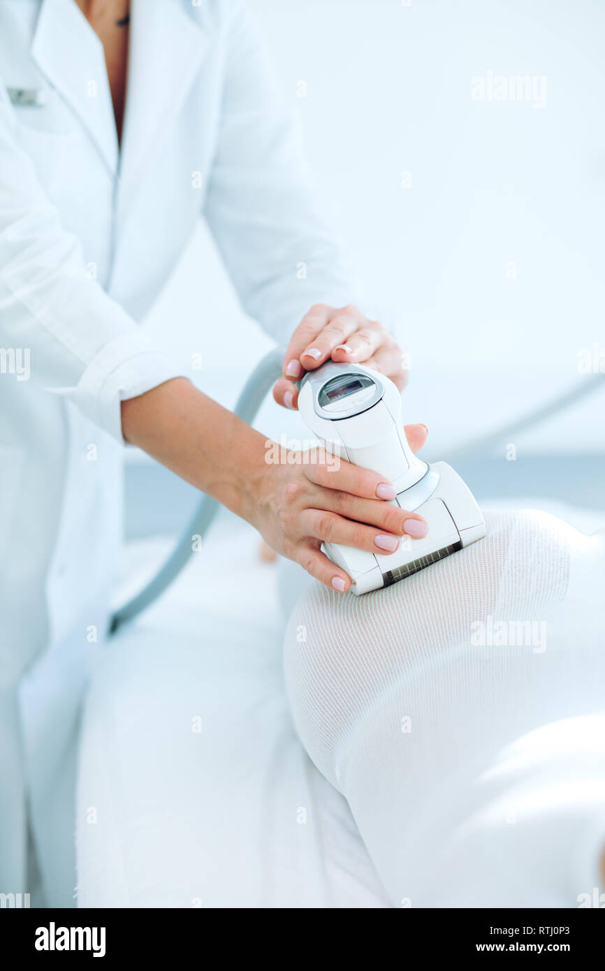 close up of female back and buttocks, in white LPG slimming bodysuit
