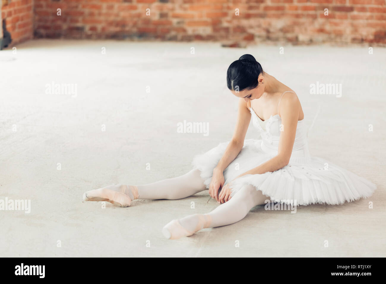 ballet dancer is tired after working out. young girl sitting with bend
