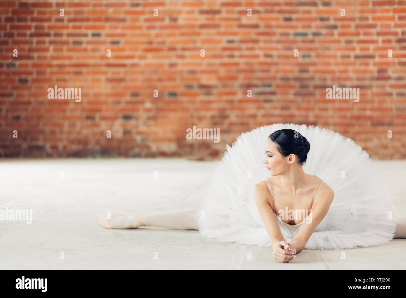 Beautiful ballerina doing the splits while lying on the floor in the ...