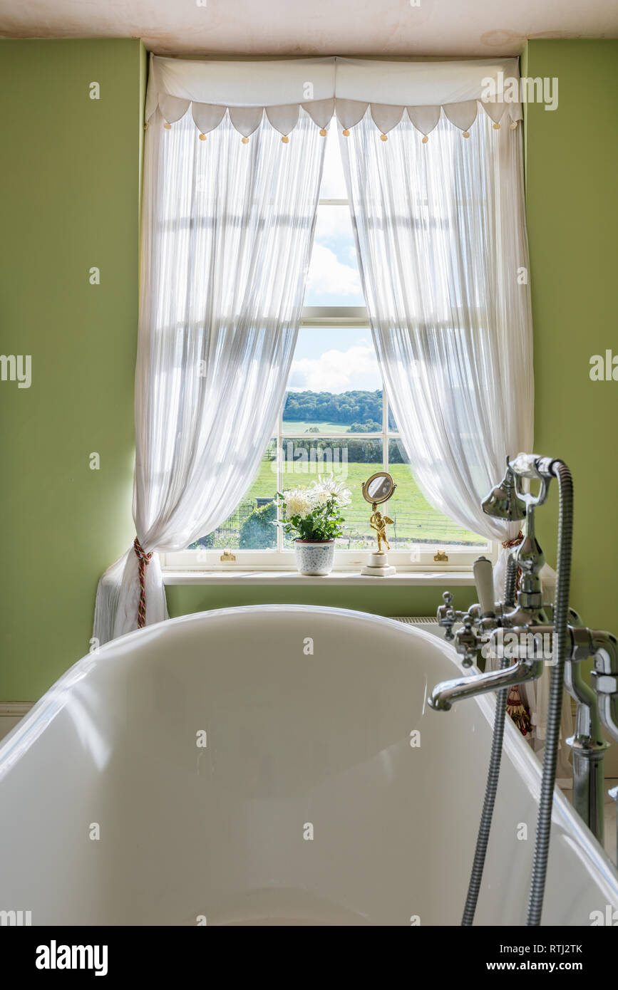 Bathroom walls painted in Green Verditer by Little Greene with view to Dorset countryside Stock Photo