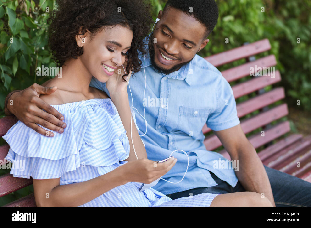 Black couple sitting on bench hi-res stock photography and images - Alamy