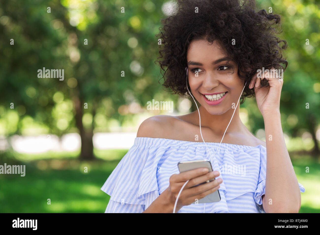 Young african-american girl listening music on smartphone Stock Photo