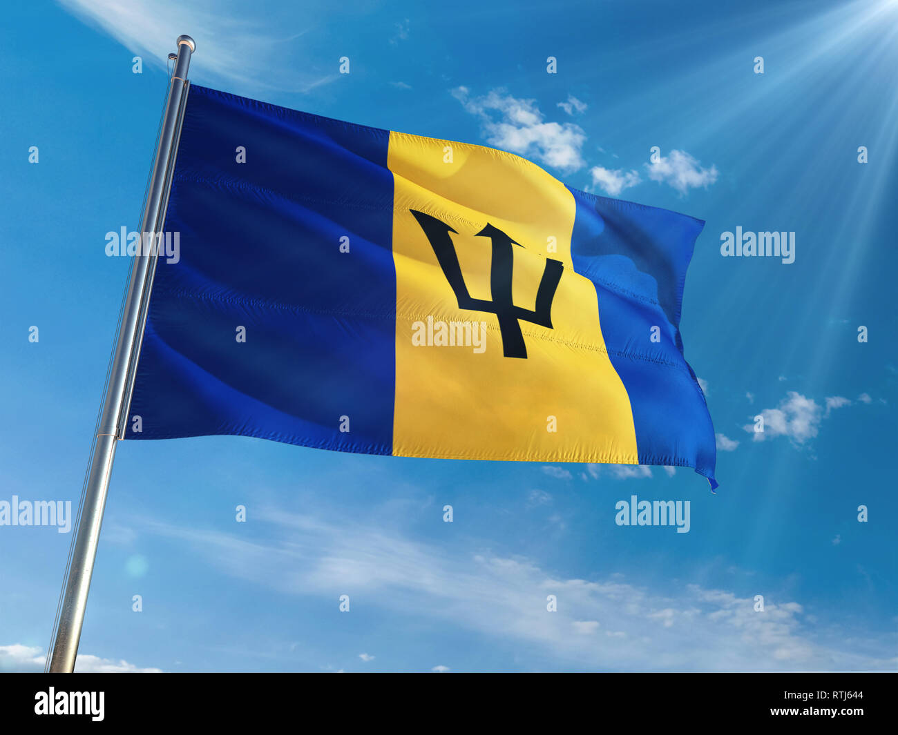 Barbados National Flag Waving on pole against sunny blue sky background. High Definition Stock Photo