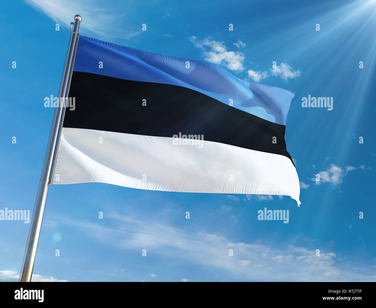 Estonia National Flag Waving on pole against sunny blue sky background ...