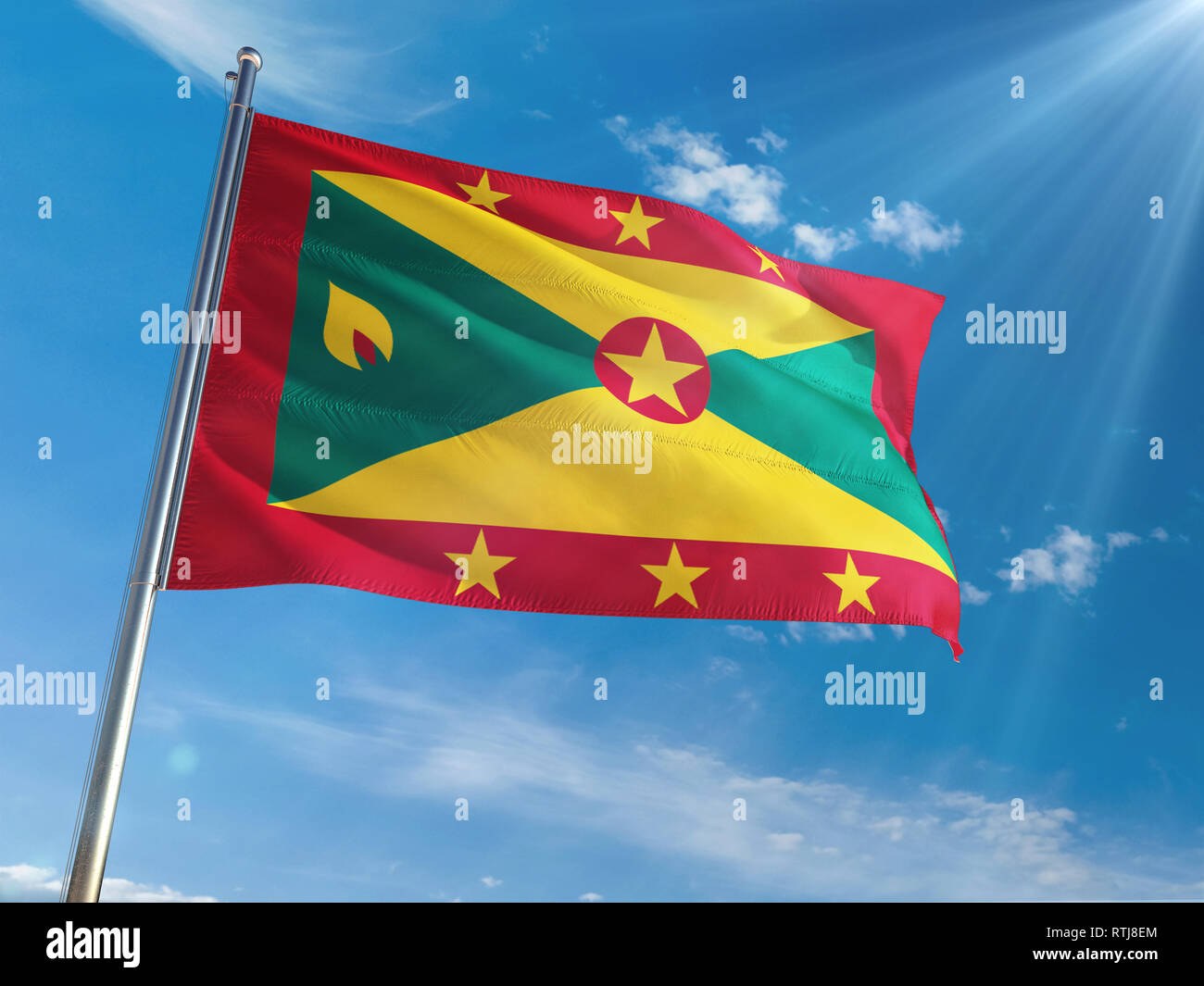 Grenada National Flag Waving on pole against sunny blue sky background