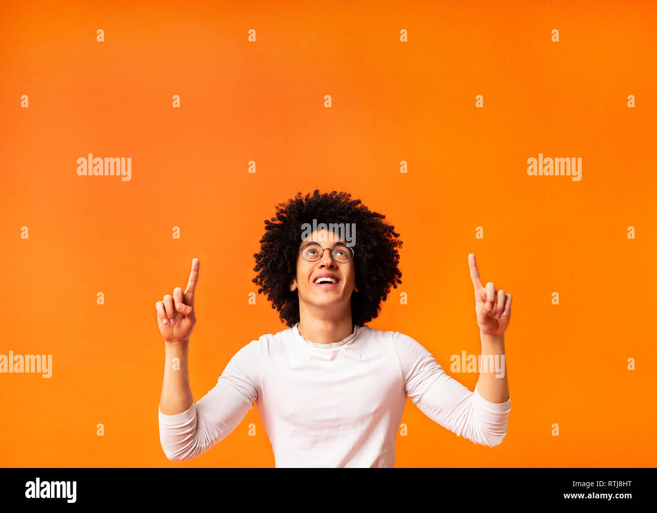 Stylish black man in glasses pointing away at empty space Stock Photo