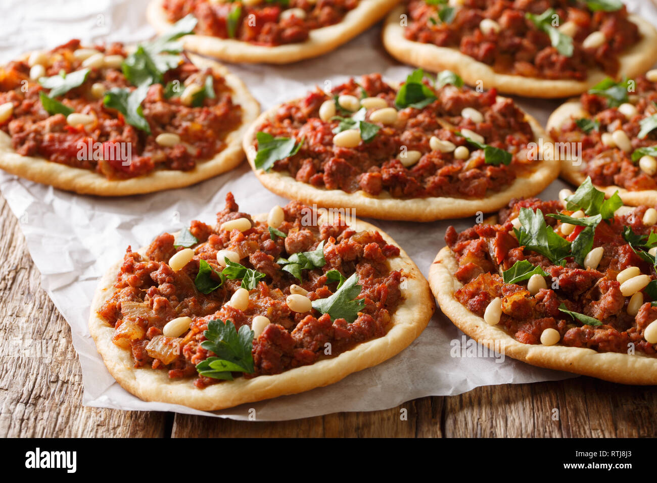 Lebanese Arab pizza with meat, tomatoes, spices and pine nuts closeup on the table. horizontal Stock Photo