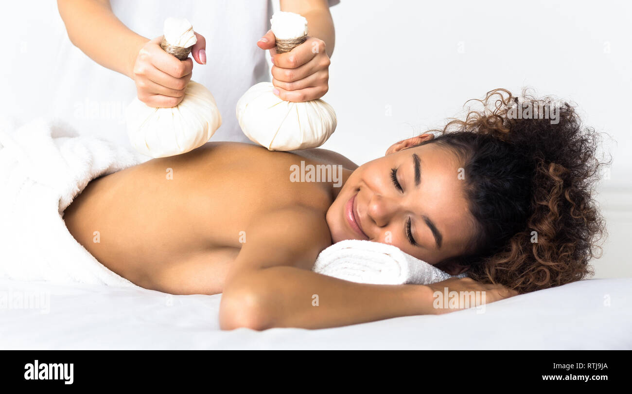 Woman having Thai herb compress massage in beauty spa Stock Photo
