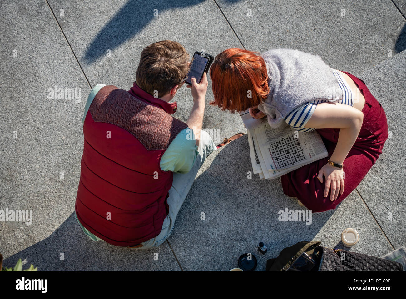 Young couple viewed from above sharing information about her crossword