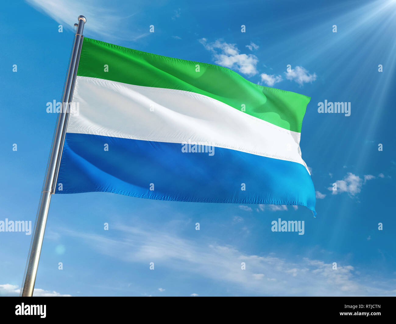 Sierra Leone National Flag Waving on pole against sunny blue sky ...