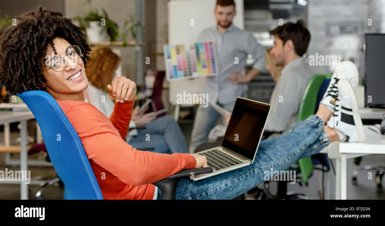 Smiling man enjoying work in modern comfortable cozy co-working space Stock Photo