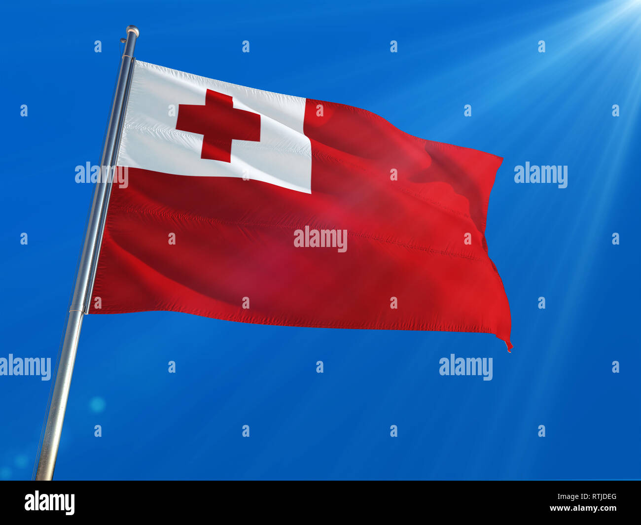 Tonga National Flag Waving on pole against deep blue sky background