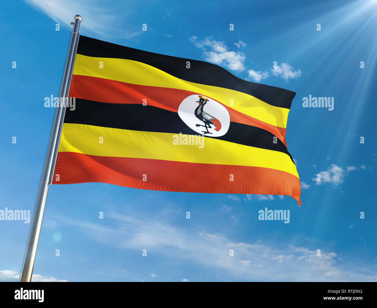 Uganda National Flag Waving on pole against sunny blue sky background