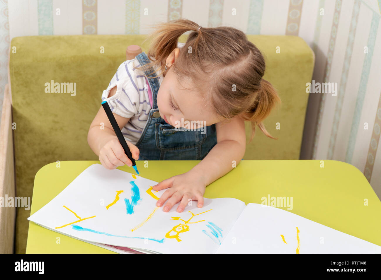 beautiful little girl concentrated on drawing with marker in a sketch pad Stock Photo