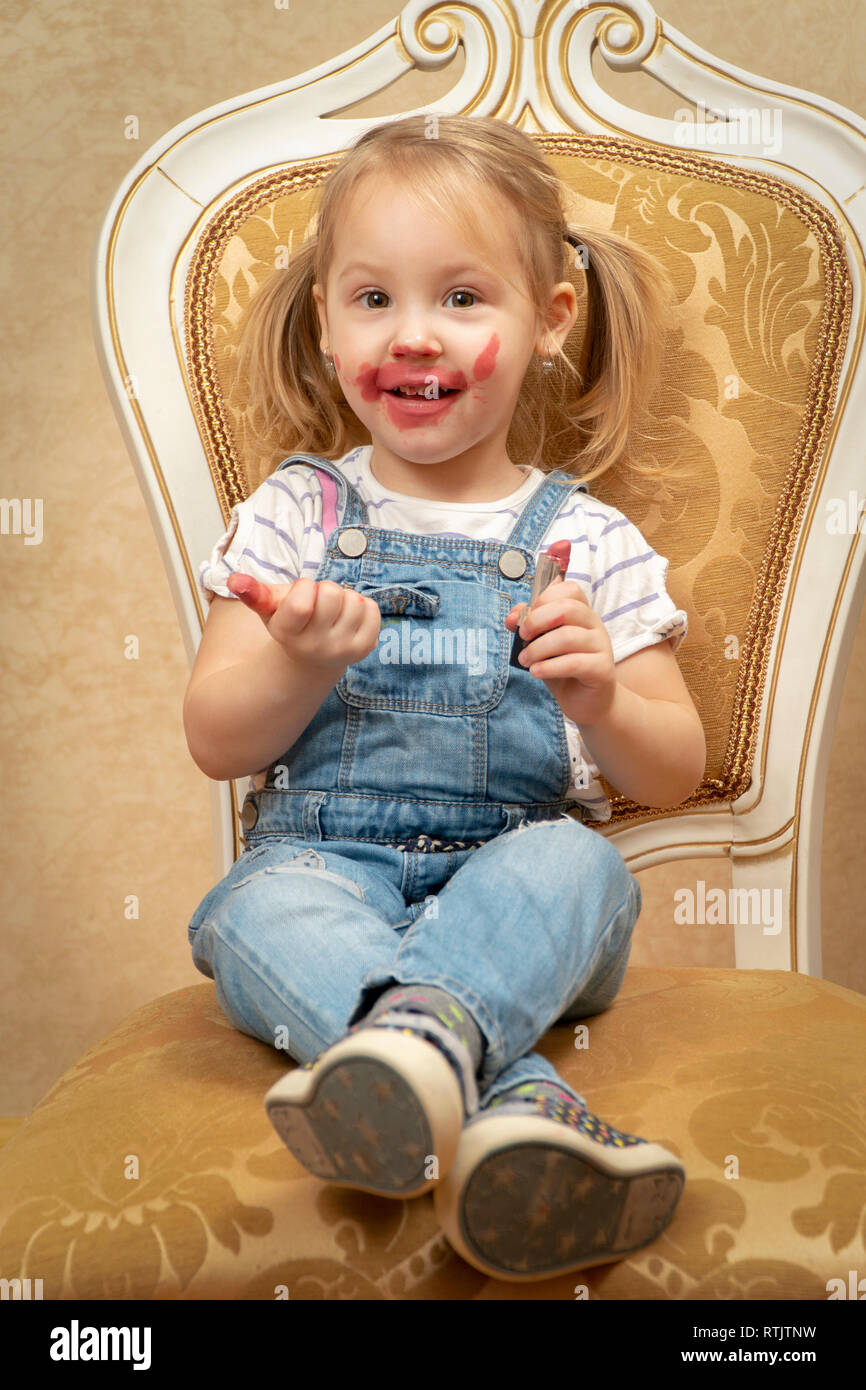 little beautiful girl sitting on a retro chair and stained with ...